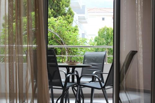 a table and chairs on a balcony with a window at Sun Village Aparthotel in Herceg-Novi