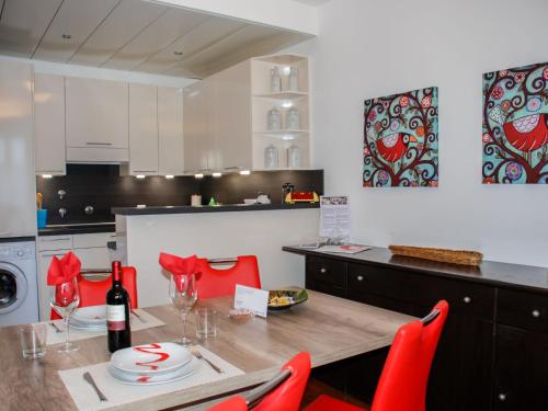 una cucina con tavolo in legno e sedie rosse di Apartment Residenza Cassarate Lago-1 a Lugano
