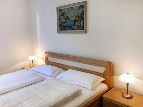 two beds in a bedroom with two lamps and a picture on the wall at Holiday Home Zum munteren Eichhörnchen by Interhome in Dittishausen