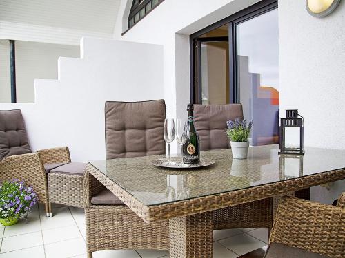 einen Esstisch mit Stühlen und eine Flasche Wein in der Unterkunft Apartment Witthuus-Langeoog by Interhome in Norddeich