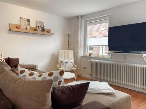 a living room with a couch and a flat screen tv at Holiday Home Hexenhuus by Interhome in Hage