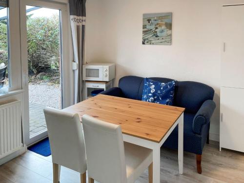 uma sala de jantar com uma mesa e um sofá azul em Holiday Home Hexenhuus by Interhome em Hage