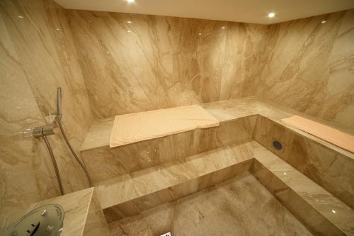a bathroom with a tub with a bed and a sink at Wellness Hotel Encian Donovaly in Donovaly