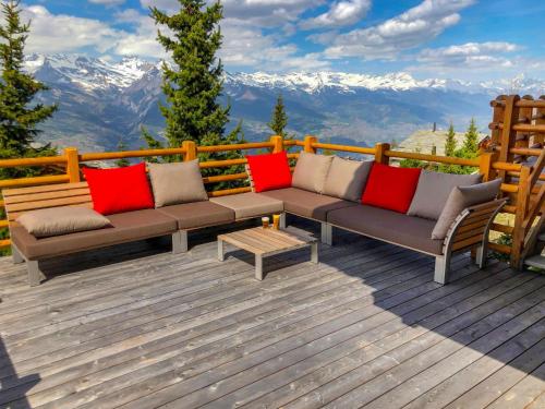 a couch on a deck with mountains in the background at Chalet Sebas by Interhome in Nendaz