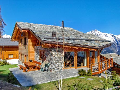 a large log cabin with mountains in the background at Chalet Sebas by Interhome in Nendaz