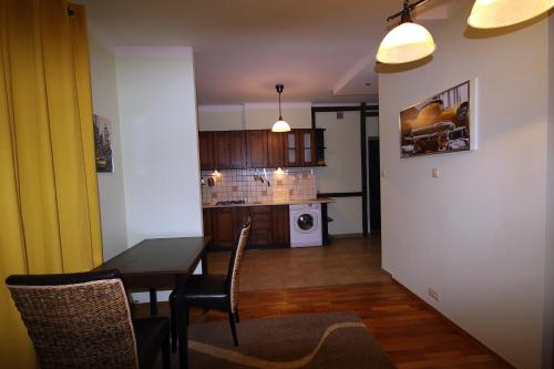 a kitchen and dining room with a table and chairs at Velvet Lazienki Park in Warsaw