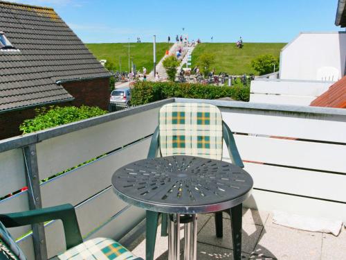 a table and chairs sitting on a balcony at Apartment Fischerstube by Interhome in Norddeich