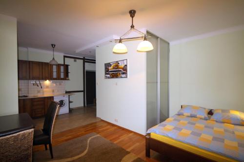 a bedroom with a bed and a table and a kitchen at Velvet Lazienki Park in Warsaw