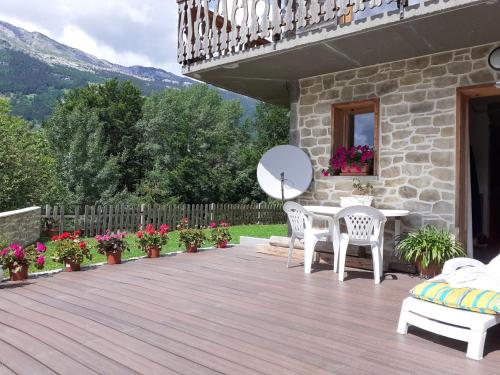 une terrasse en bois avec une table et des chaises sur une maison dans l'établissement Apartment Namasté by Interhome, à Les Villards-sur-Thônes