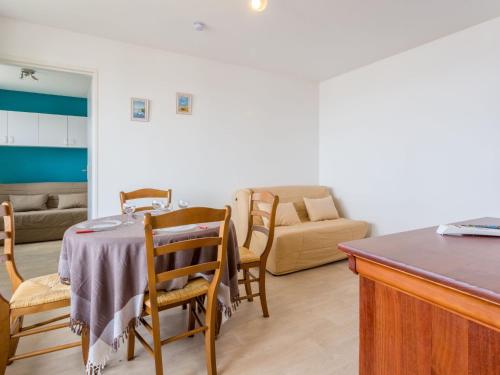 sala de estar con mesa, sillas y sofá en Apartment les Colombières by Interhome, en Villers-sur-Mer