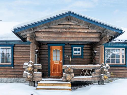 a log cabin in the snow with a door at Holiday Home Hanhela by Interhome in Äkäslompolo