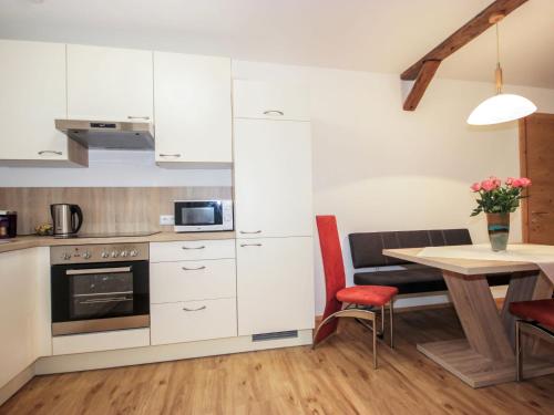 - une cuisine et une salle à manger avec des placards blancs et une table dans l'établissement Apartment Matilda by Interhome, à Ried im Oberinntal