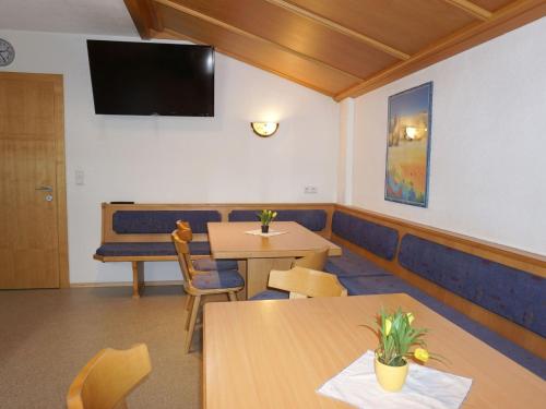 a waiting room with tables and a tv on the wall at Apartment Stark by Interhome in Pettneu am Arlberg