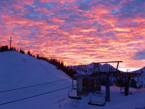 a sunset with a ski lift in the snow at Apartment Gipfelkreuz by Interhome in Donnersbachwald