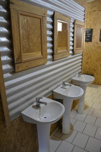 a bathroom with two sinks and two windows at Camping Güino in Puerto Natales