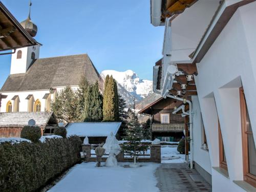 a courtyard with snow covered buildings and a mountain at Apartment Poldi by Interhome in Haus im Ennstal