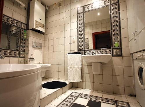 a bathroom with a sink and a washing machine at Velvet Apartament Kopińska in Warsaw