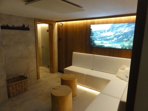 a living room with a white couch and a tv at Quartier Severin in Berwang