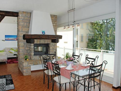 een eetkamer met een tafel en stoelen en een open haard bij Apartment Casa Zappa by Interhome in Brusino Arsizio