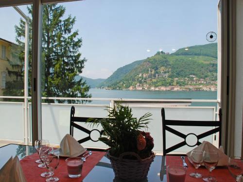 Brusino ArsizioにあるApartment Casa Zappa by Interhomeの水辺の景色を望むダイニングテーブル