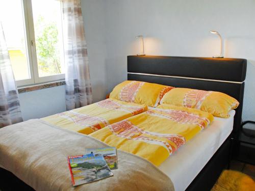 - une chambre dotée d'un lit avec des draps jaunes et oranges dans l'établissement Apartment Giardinetto by Interhome, à San Nazzaro