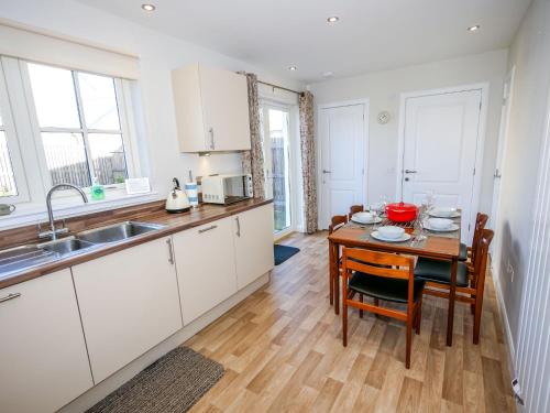 een keuken met een houten tafel en een eetkamer bij Holiday Home Devonvale Place by Interhome in Kinross