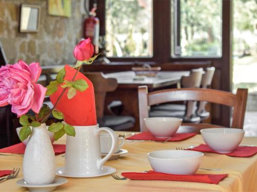 stół z dwoma białymi wazami i różową różą w obiekcie Villa Tenuta Valente by Interhome w mieście Giungano