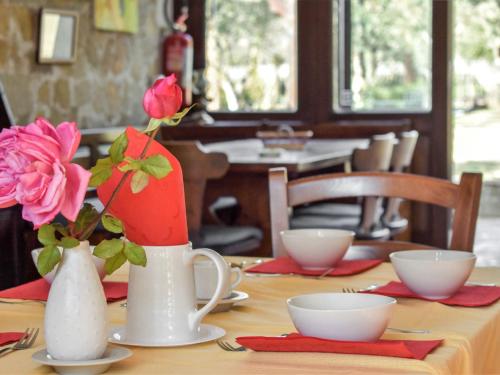 GiunganoにあるVilla Tenuta Valente by Interhomeの白花瓶2本とピンクのバラが飾られたテーブル