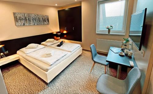 - une chambre avec un lit, un bureau, une table et une chaise dans l'établissement Hotel Zlaté Košice, à Košice