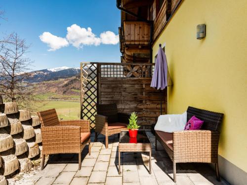 eine Terrasse mit Stühlen, einer Couch und einem Tisch in der Unterkunft Apartment Mooslehen-1 by Interhome in Schattberg