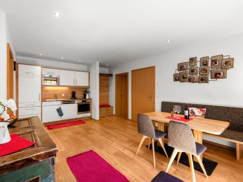 eine Küche und ein Wohnzimmer mit einem Holztisch und Stühlen in der Unterkunft Apartment Mooslehen-1 by Interhome in Schattberg