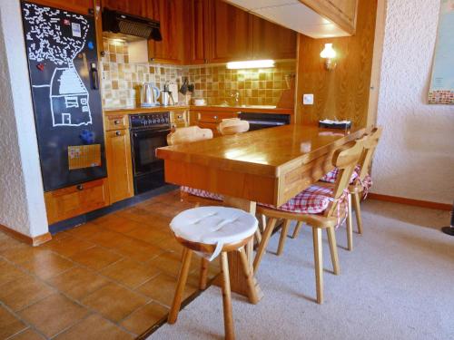 a kitchen with a wooden table and chairs at Apartment Les Aiguilles d'Argent 10 by Interhome in Chesières