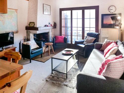 a living room with couches and a tv and a fireplace at Apartment Les Aiguilles d'Argent 10 by Interhome in Chesières