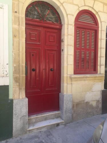 una puerta roja en el lateral de un edificio en The Red Door en Tas-Samra
