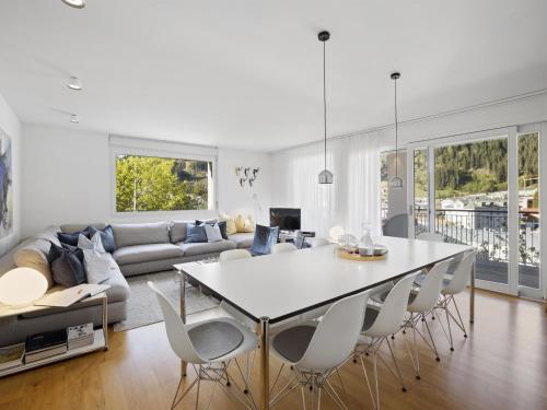 una sala de estar blanca con mesa y sillas en Apartment Liebrand by Interhome, en Churwalden