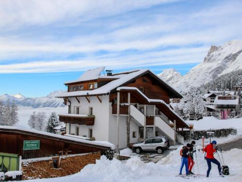 a group of people on skis in front of a building at Apartment Renauer by Interhome in Mösern