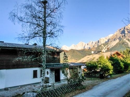 a house with a tree in front of a mountain at Holiday Home Berghaus Weitblick by Interhome in Ramsau am Dachstein