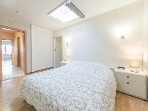 a white bedroom with a large bed and a skylight at Apartment Maria Ter Duyne II by Interhome in Mispelburg