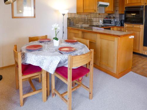 a kitchen with a table with red plates on it at Apartment Aiguilles Dorées III-2 by Interhome in Villars-sur-Ollon