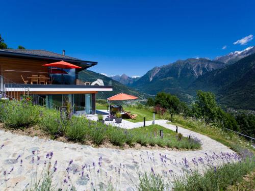 a house on a hill with mountains in the background at Apartment Zenkei by Interhome in Leontica