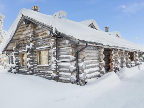 ルカにあるHoliday Home Kelovalta 7b by Interhomeの雪に覆われた古い丸太小屋