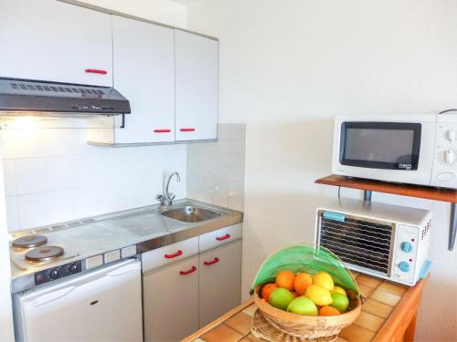 eine Küche mit einer Schale Obst und einer Mikrowelle in der Unterkunft Apartment Zirlinga-7 by Interhome in Bidart