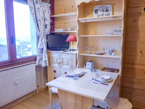 Cette chambre dispose d'une table, d'une télévision et d'étagères. dans l'établissement Studio Le Bois du Bouchet-6 by Interhome, à Chamonix-Mont-Blanc