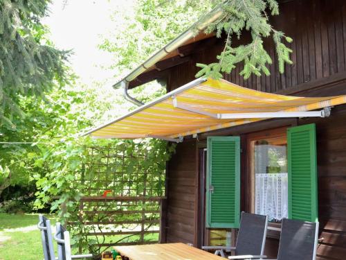 a wooden house with a table and an umbrella at Chalet Menardi by Interhome in Frankenburg