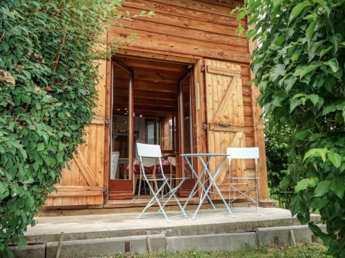 zwei Stühle und ein Tisch vor einem Gebäude in der Unterkunft Holiday Home Les Farfadets by Interhome in Saint-Gervais-les-Bains
