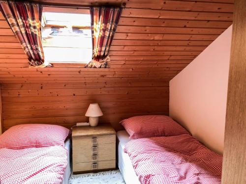 two beds in a attic room with a window at Apartment Römer by Interhome in Bad Hofgastein