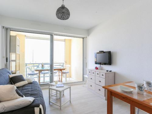 a living room with a couch and a table at Apartment Grand Pavois-4 by Interhome in Mimizan-Plage