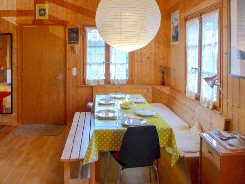 a dining room with a table and a lamp at Apartment Rondeau by Interhome in Zinal