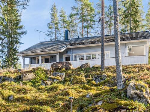 une maison sur une colline avec des arbres et des rochers dans l'établissement Holiday Home Kainaloranta by Interhome, à Kolinkylä