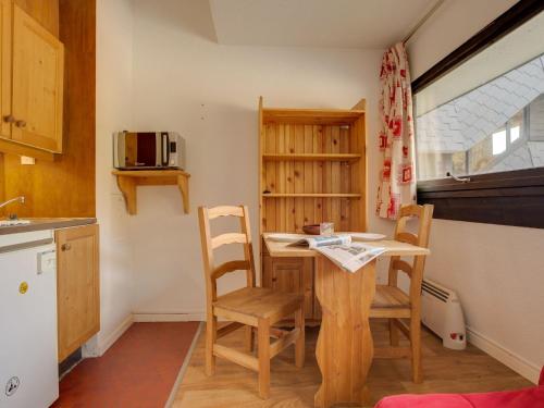 une cuisine avec une table et des chaises dans une pièce dans l'établissement Studio Brelins Les Combes 942 by Interhome, aux Menuires
